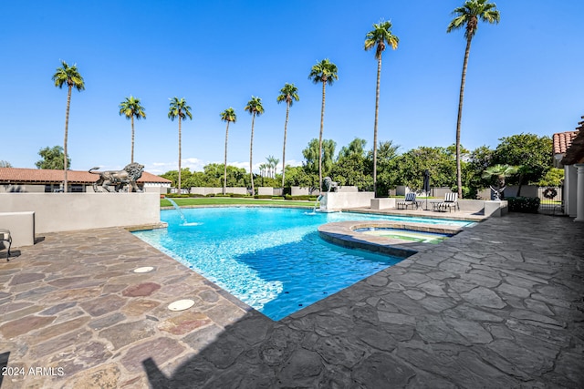 view of pool featuring an in ground hot tub, pool water feature, and a patio area