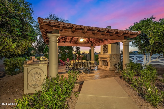 patio terrace at dusk with an outdoor kitchen and a gazebo