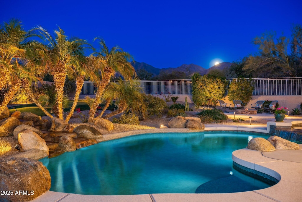 pool at twilight featuring a mountain view