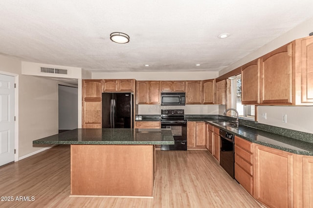 1203 E Bishop Dr, Tempe, AZ 85282 - kitchen featuring visible vents, light wood-style floors, a center island, a sink, and black appliances