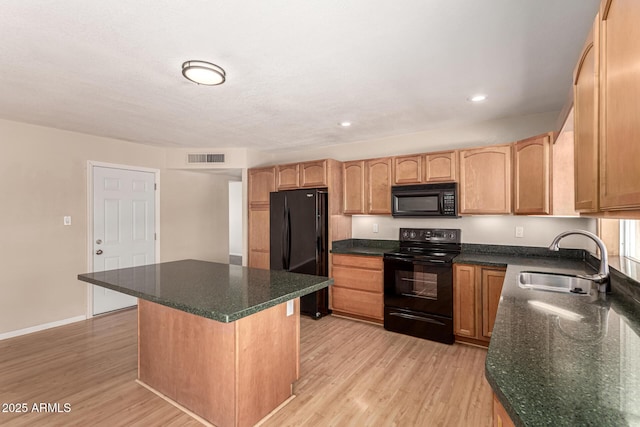 1203 E Bishop Dr, Tempe, AZ 85282 - kitchen featuring a kitchen island, visible vents, a sink, black appliances, and light wood-style flooring