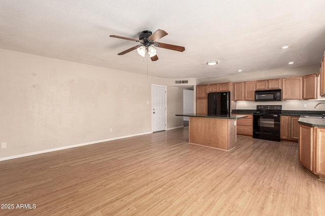 1203 E Bishop Dr, Tempe, AZ 85282 - kitchen with visible vents, dark countertops, a center island, a sink, and black appliances