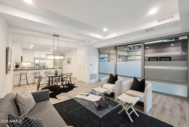 living room with an inviting chandelier and light hardwood / wood-style floors