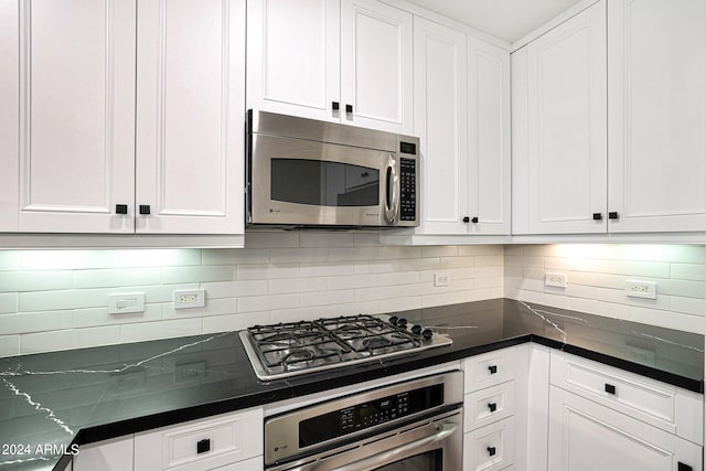 kitchen with white cabinets, appliances with stainless steel finishes, and backsplash