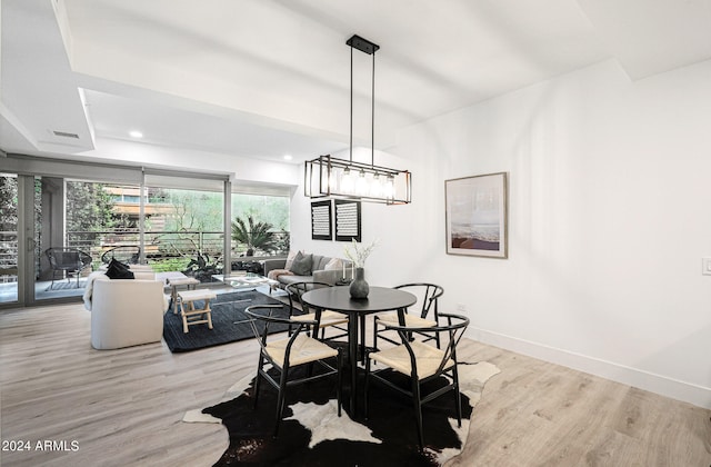 dining space featuring light hardwood / wood-style floors and a notable chandelier