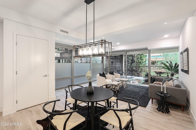 dining area with a chandelier and light hardwood / wood-style floors