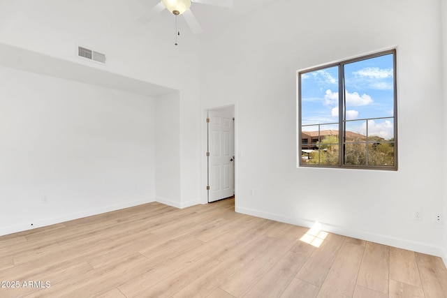 spare room featuring a ceiling fan, light wood-style flooring, and baseboards