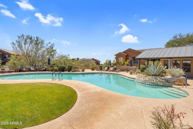 community pool with a patio and a lawn
