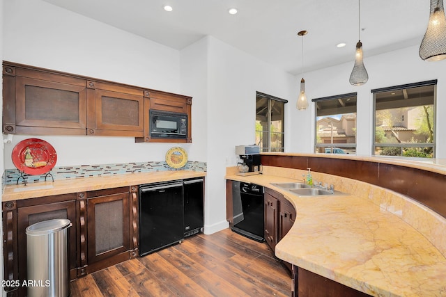 kitchen featuring black appliances, a sink, dark wood-type flooring, recessed lighting, and glass insert cabinets