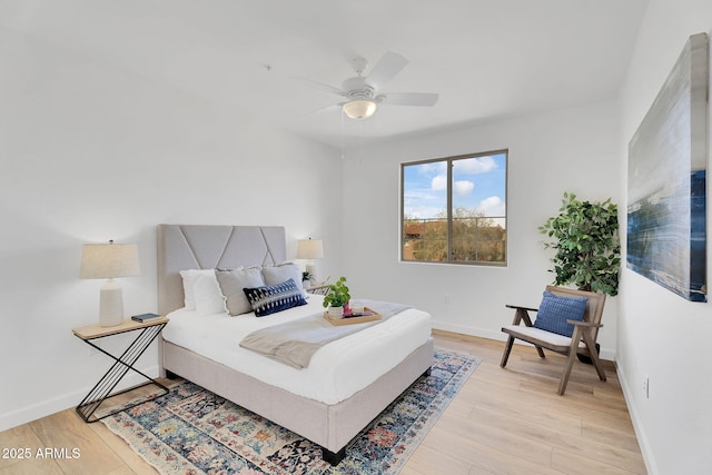 bedroom with light wood-type flooring, baseboards, and a ceiling fan
