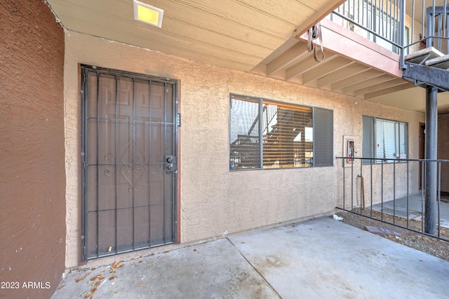 property entrance with a patio area and a balcony