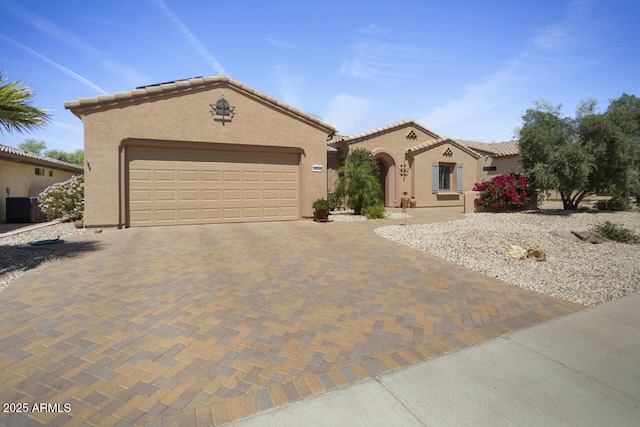 19714 N Concord Dr, Surprise, AZ 85374 - mediterranean / spanish-style home featuring cooling unit, stucco siding, decorative driveway, and an attached garage