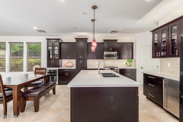 kitchen featuring light countertops, stainless steel microwave, a sink, and visible vents