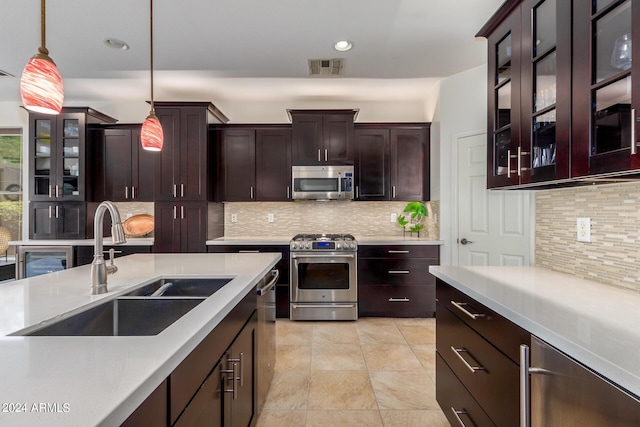 kitchen featuring stainless steel appliances, a sink, visible vents, light countertops, and pendant lighting