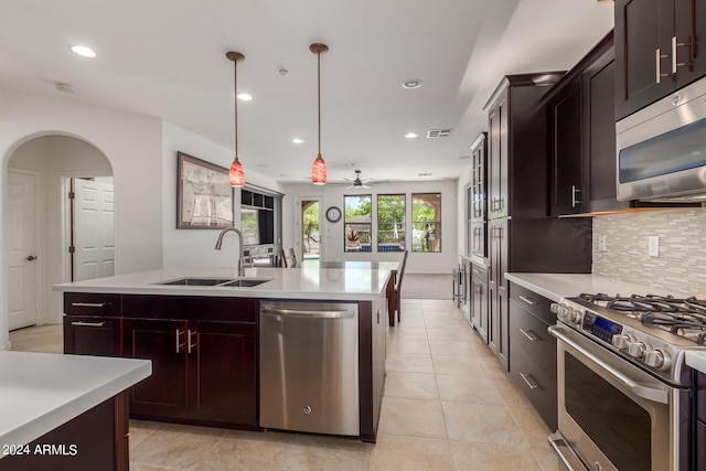 kitchen with stainless steel appliances, a sink, visible vents, light countertops, and decorative backsplash