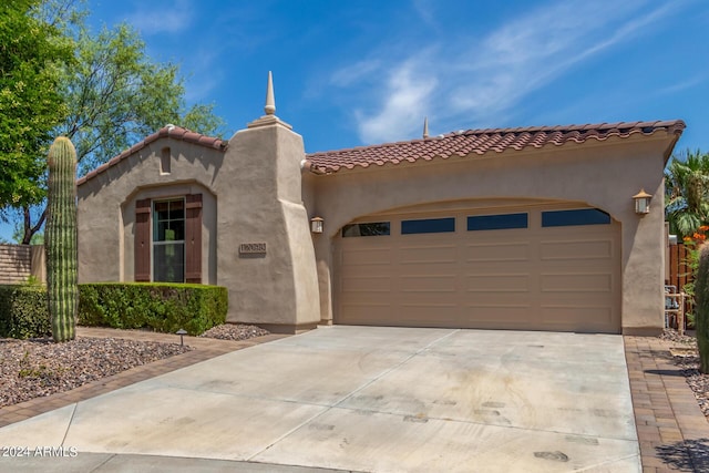 mediterranean / spanish house featuring a garage, concrete driveway, and stucco siding