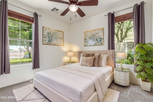 carpeted bedroom with ceiling fan, visible vents, and baseboards