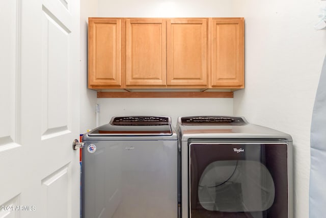 clothes washing area with cabinet space and separate washer and dryer