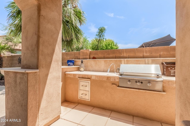 view of patio with fence, an outdoor kitchen, and area for grilling