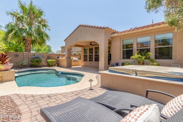 view of pool with an outdoor kitchen, fence, a fenced in pool, a patio area, and a hot tub