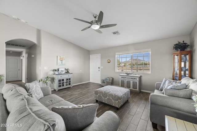 living room featuring ceiling fan and dark wood-type flooring