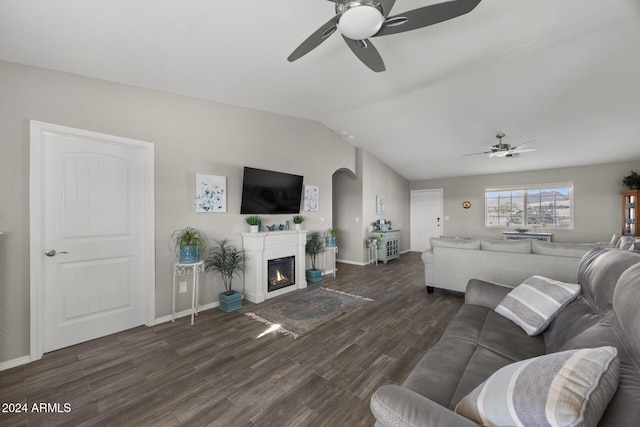 living room featuring ceiling fan, dark hardwood / wood-style flooring, and vaulted ceiling