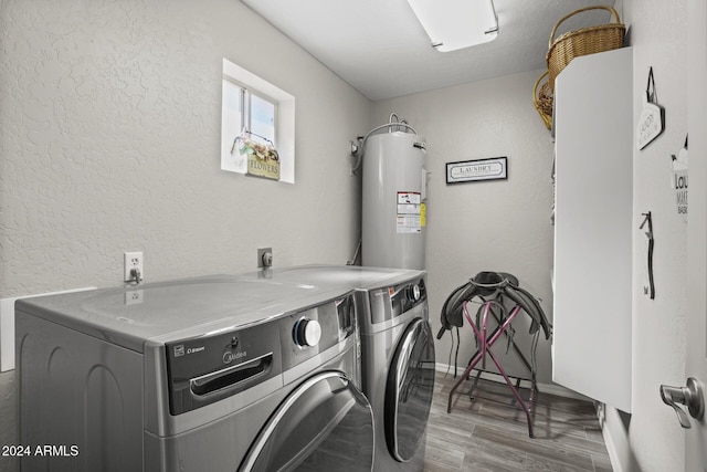 laundry room with electric water heater, independent washer and dryer, and light hardwood / wood-style flooring