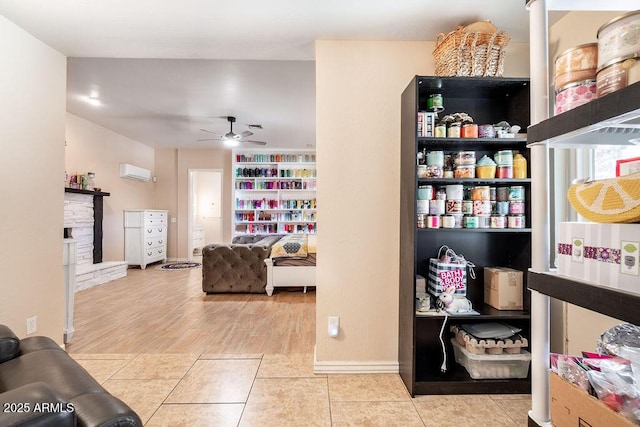 interior space featuring a fireplace, a wall unit AC, and ceiling fan