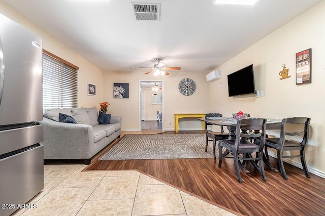 tiled living room featuring a wall mounted air conditioner and ceiling fan