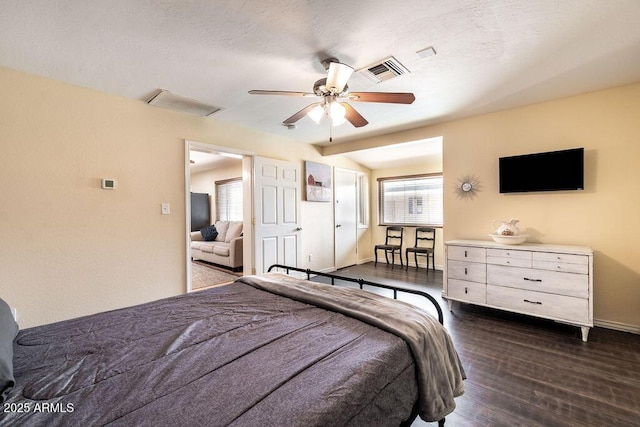 bedroom with ceiling fan, dark hardwood / wood-style flooring, and a textured ceiling