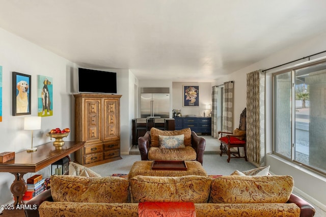 living room featuring baseboards and light colored carpet