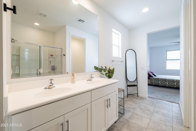 bathroom featuring visible vents, a sink, and a shower stall