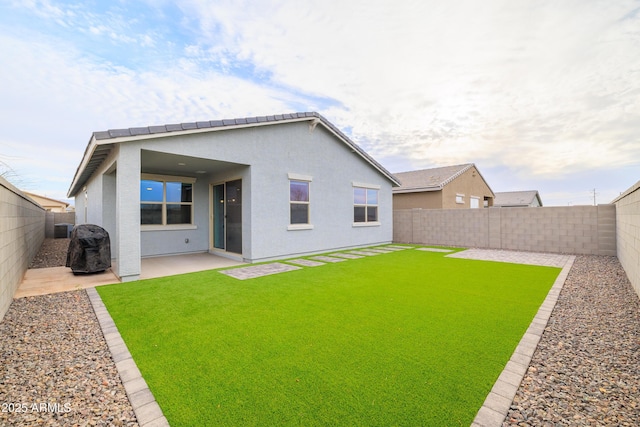 back of property with a patio area, a fenced backyard, a lawn, and stucco siding