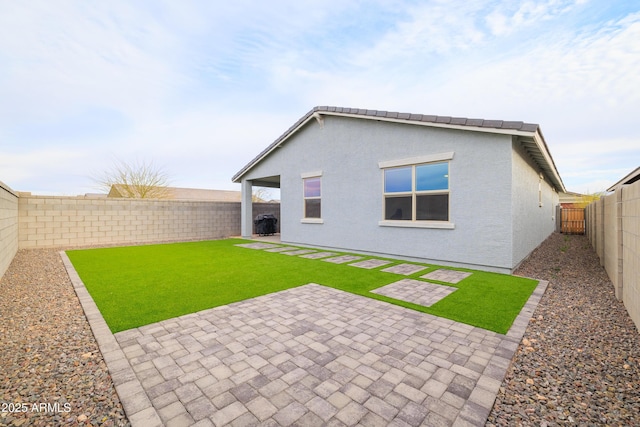 back of property featuring a patio, a yard, a fenced backyard, and stucco siding