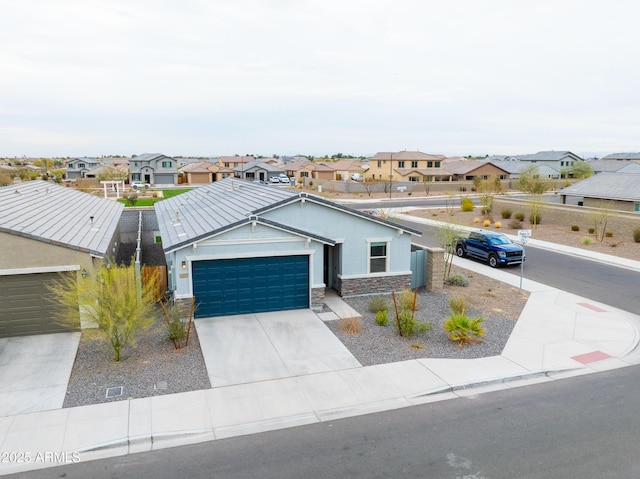 view of front facade featuring stucco siding, a garage, a residential view, stone siding, and driveway