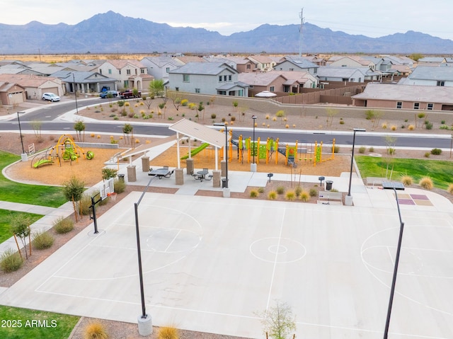 exterior space with a residential view, fence, playground community, community basketball court, and a mountain view