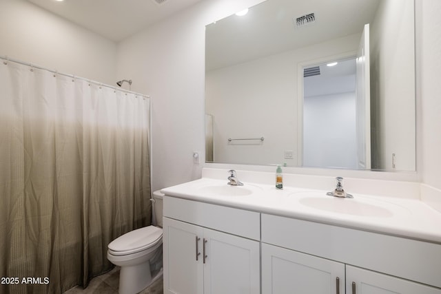 full bathroom featuring toilet, double vanity, visible vents, and a sink