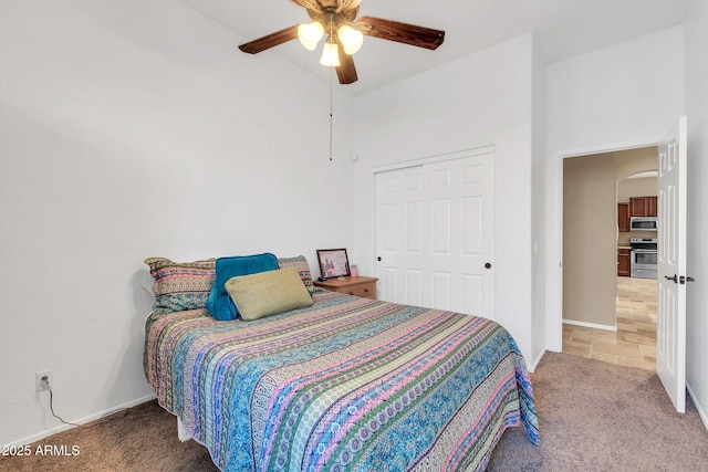 bedroom with ceiling fan, a closet, carpet flooring, and baseboards