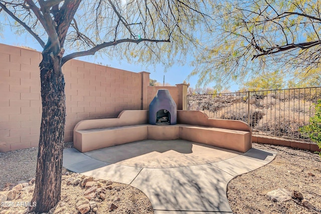 view of patio / terrace featuring a fenced backyard and exterior fireplace