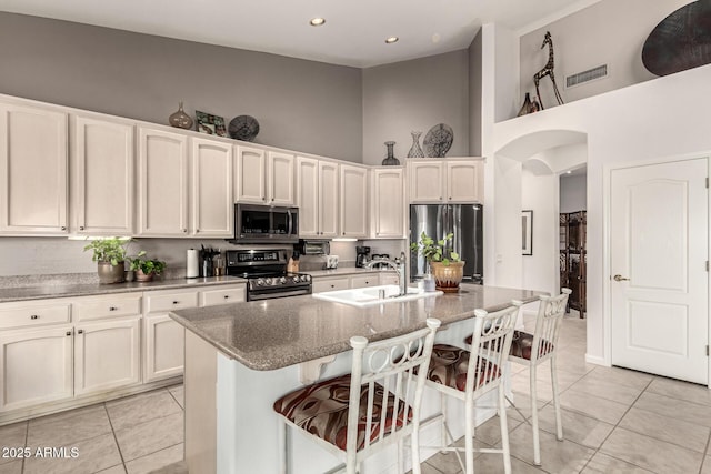 18021 N 53rd St, Scottsdale, AZ 85254 - kitchen with appliances with stainless steel finishes, a towering ceiling, light tile patterned floors, arched walkways, and a sink
