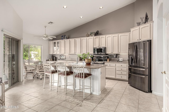 18021 N 53rd St, Scottsdale, AZ 85254 - kitchen with appliances with stainless steel finishes, high vaulted ceiling, a sink, ceiling fan, and a center island with sink