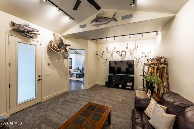 living room featuring vaulted ceiling, rail lighting, ceiling fan, and dark colored carpet