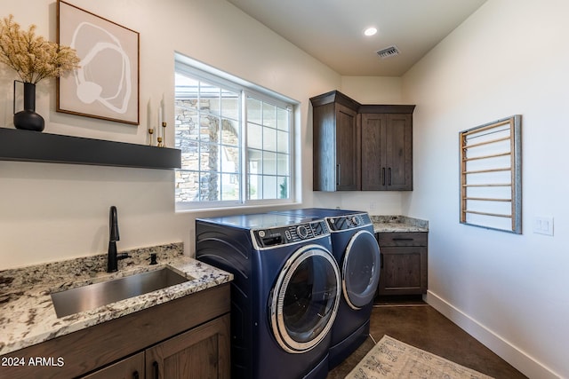 laundry room with sink, a wealth of natural light, washer and clothes dryer, and cabinets