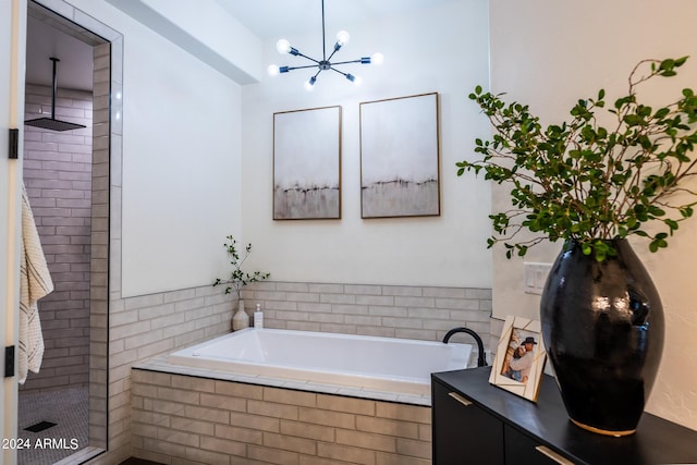 bathroom featuring a chandelier and independent shower and bath