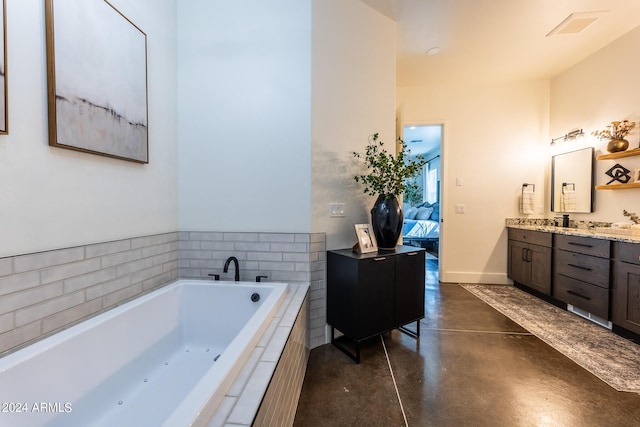 bathroom featuring vanity, concrete flooring, and tiled bath