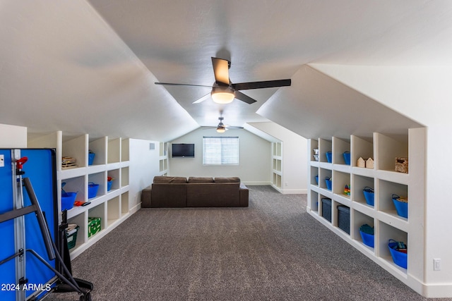 game room with vaulted ceiling, ceiling fan, dark carpet, and built in shelves