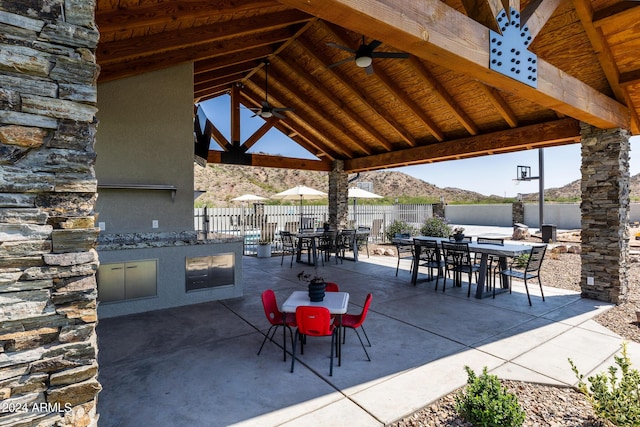 view of patio featuring a mountain view, a gazebo, ceiling fan, and exterior kitchen