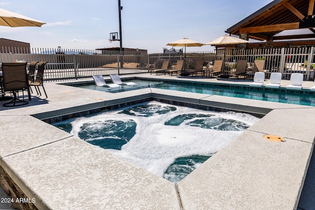 view of swimming pool with an in ground hot tub