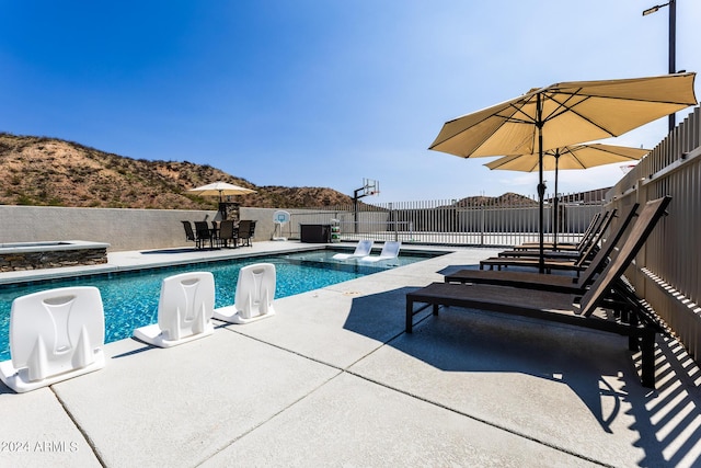 view of swimming pool featuring an in ground hot tub and a patio