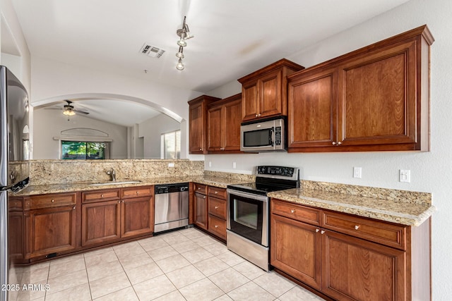 3152 N 83rd Pl, Scottsdale, AZ 85251 - kitchen with appliances with stainless steel finishes, a ceiling fan, light tile patterned floors, arched walkways, and lofted ceiling